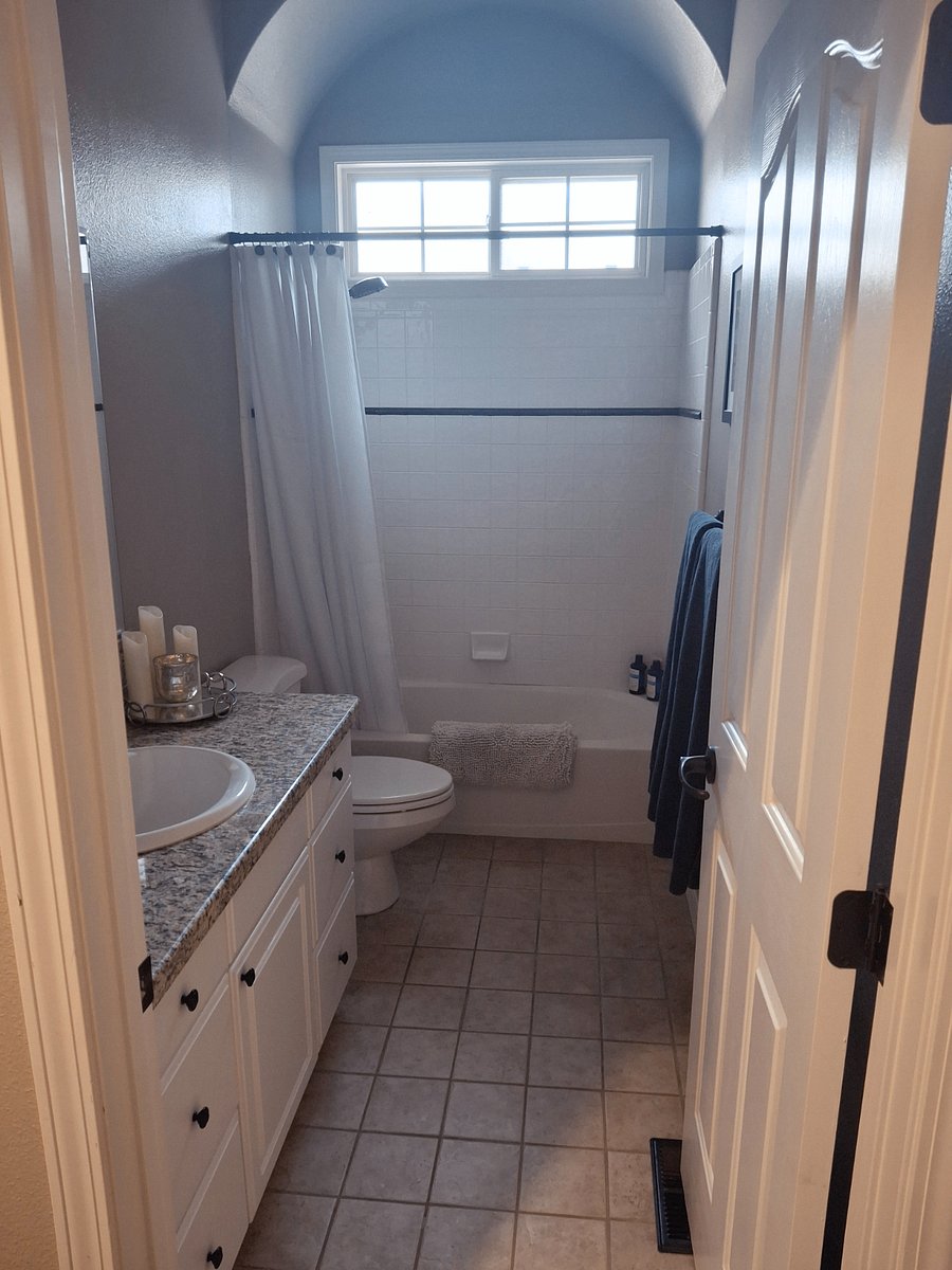 Roomy and bright full bath featuring new hardware and Lacoste towels