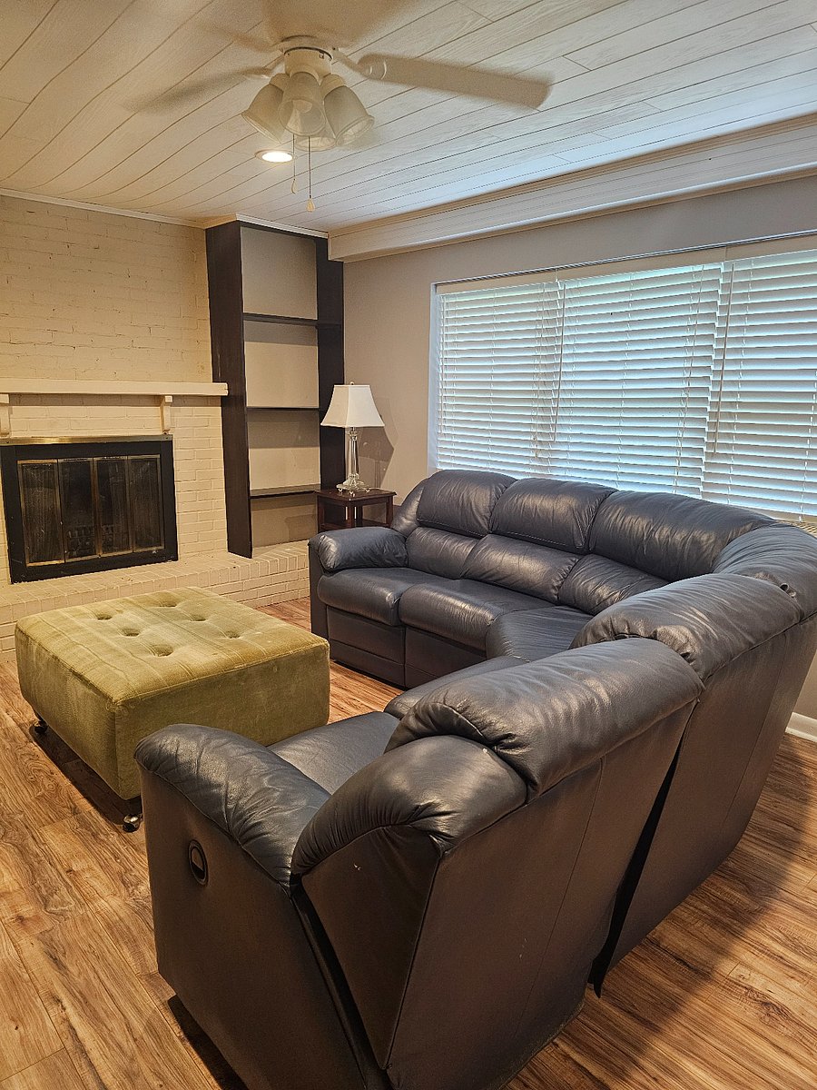 Living room with sectional sofa with recliners, fireplace is decorative