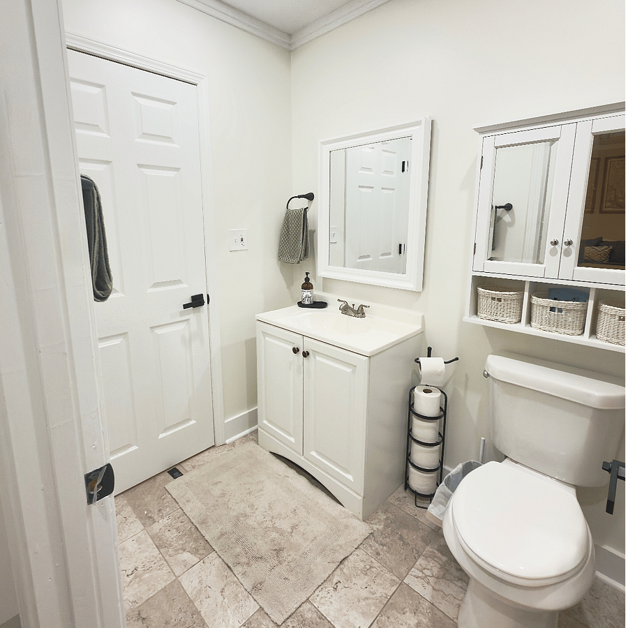 This room has the full bath (shower, toilet, sink), and the adjoining smaller room with just a toilet and sink is the half-bath attached to the main one.