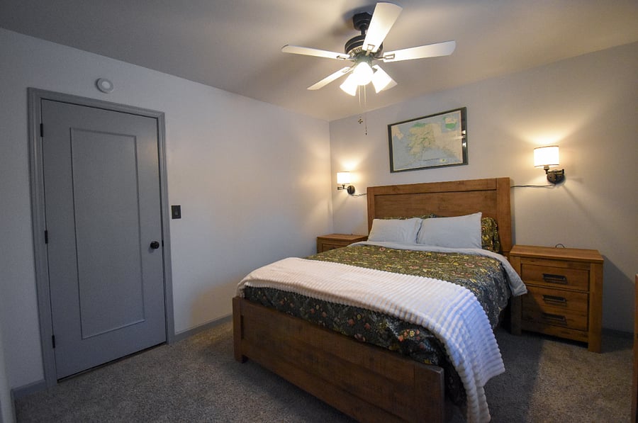 Cozy queen bedroom with dimmable bedside lamps, blackout curtains, and a full closet. Enjoy local art, a dresser, and thoughtful extras like a white noise machine, earplugs, and hot tub robes.
