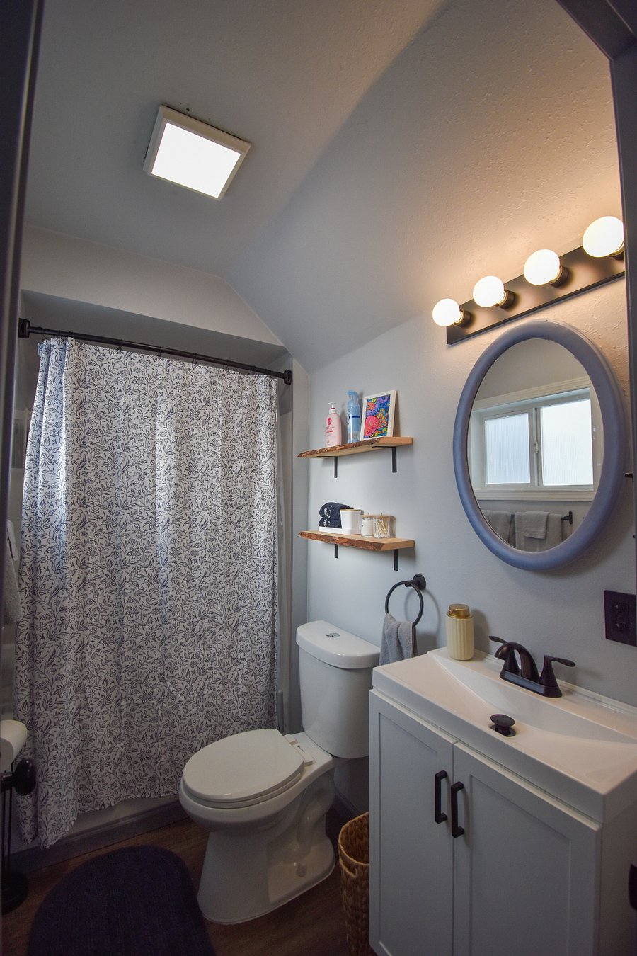 Bright, clean bathroom with a tub and shower, soft towels, and extra linens. Stocked with shampoo, lotion, feminine products, hair dryer, and other essentials like Q-tips, makeup towels, and air freshener.