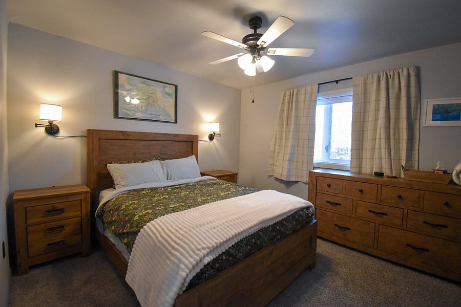 Cozy queen bedroom with dimmable bedside lamps, blackout curtains, and a full closet. Enjoy local art, a dresser, and thoughtful extras like a white noise machine, earplugs, and hot tub robes.