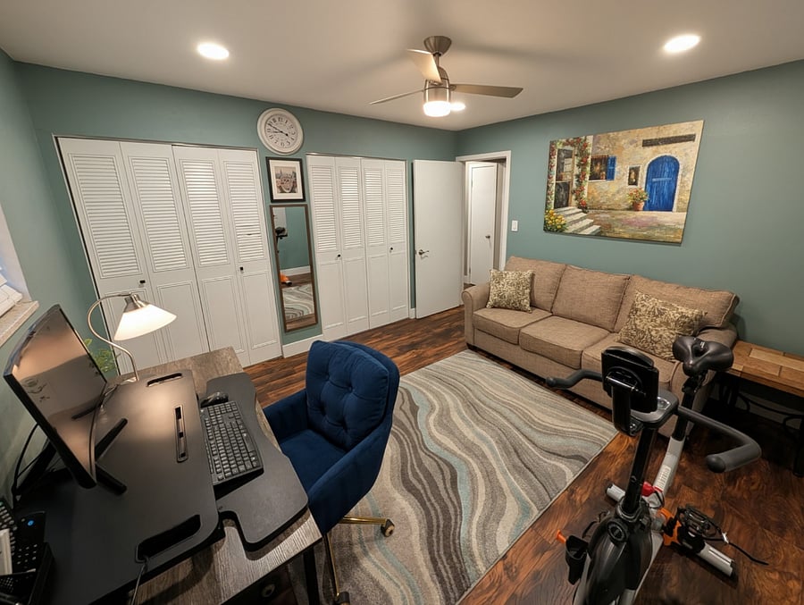 Spare room. Multi-use space with an exercise bike, pull out queen size couch, and standing desk office set up. 