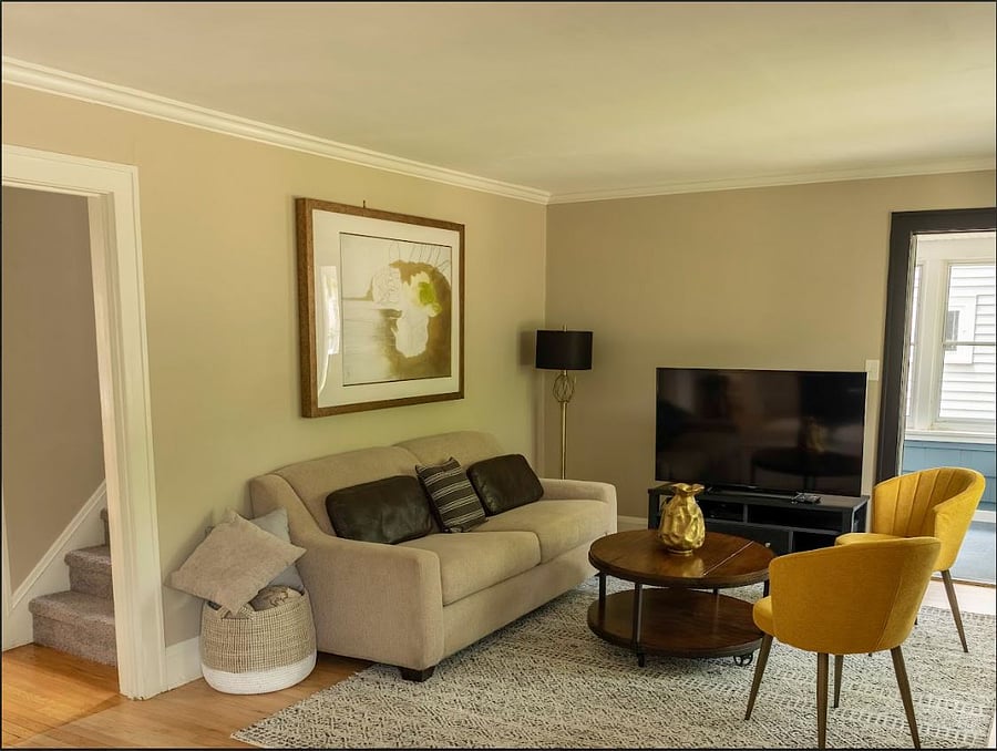 Living room with entrance to kitchen on left, just past the stairs.  Doorway on right leads to sun room