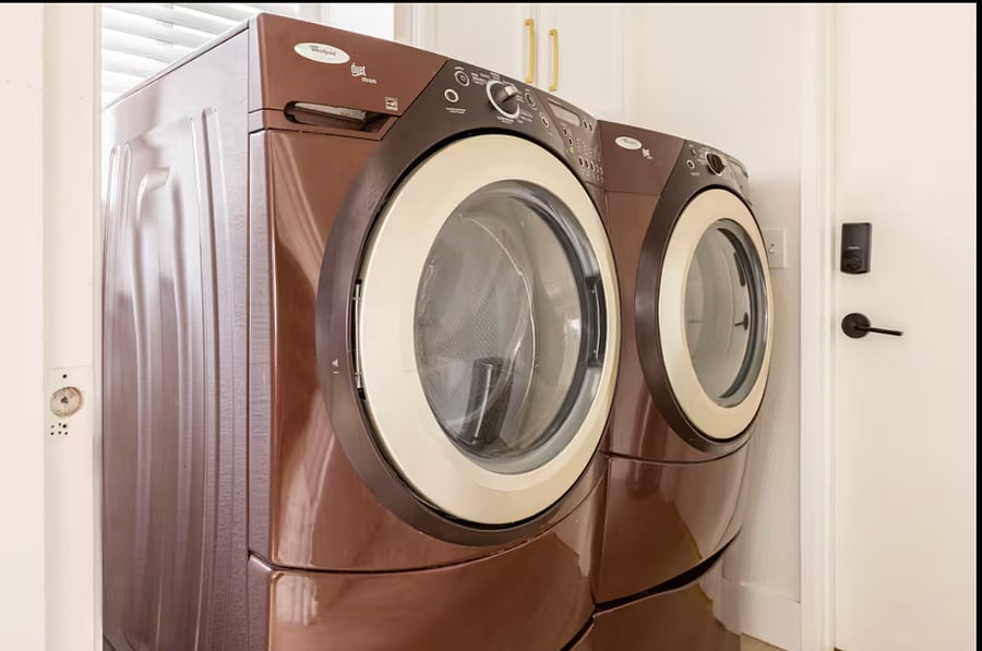 Front loading washer/dryer located next to kitchen/dining nook. The door pictured is the entrance to the 2 car garage.