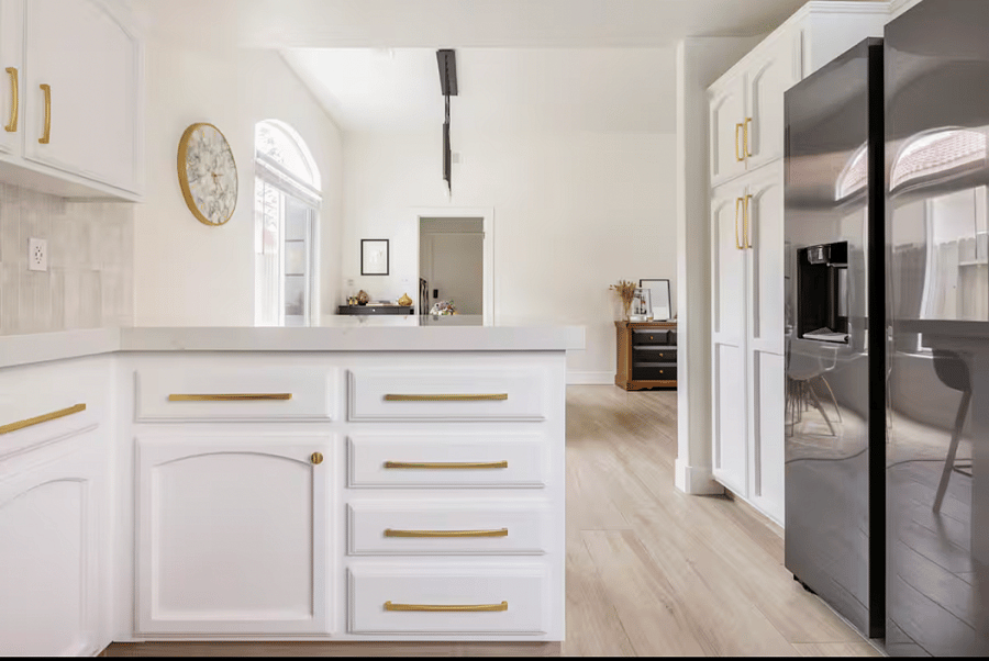 The kitchen cabinets feature a fresh, non-scratch paint finish, complemented by custom hardware