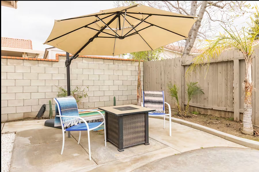 The firepit area has been upgraded with a cozy loveseat, two large cushioned chairs, and additional bench seating for relaxing and entertaining.