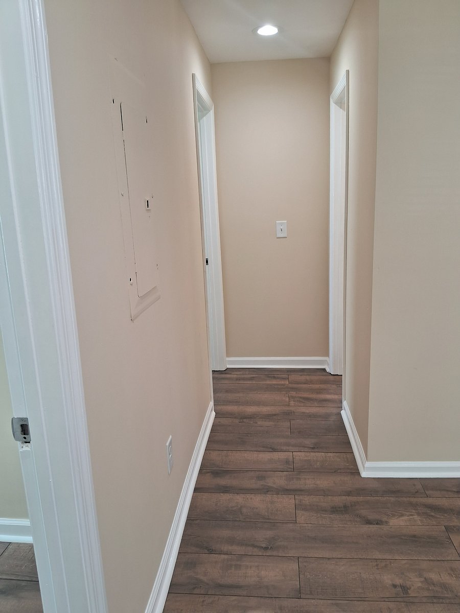 Short central hallway between bedroom 3 and bathroom, leading from open central house space.