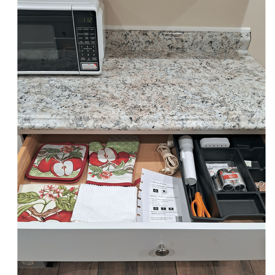 Kitchen linen drawer includes flashlight and extra batteries.