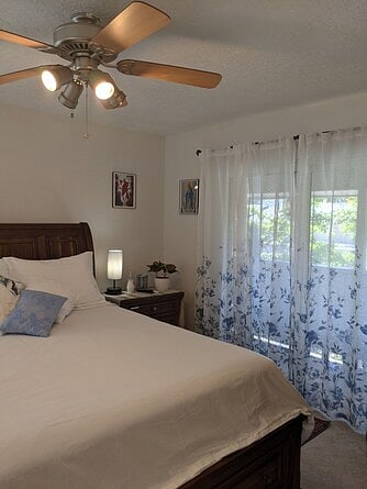 Main floor bedroom with queen size bed, sliding doors to balcony, dressing area, walk-in closet and private bathroom.