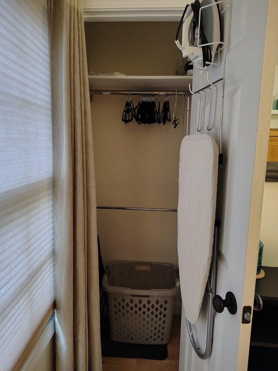 closet for hanging clothes and iron with ironing board