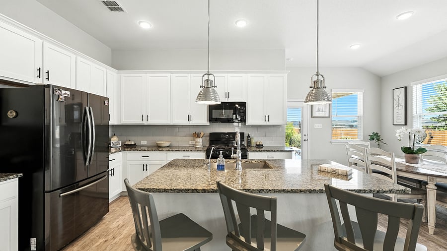 Open kitchen with white cabinetry, stainless steel appliances, and plenty of counter spacefully set up for real-life cooking.