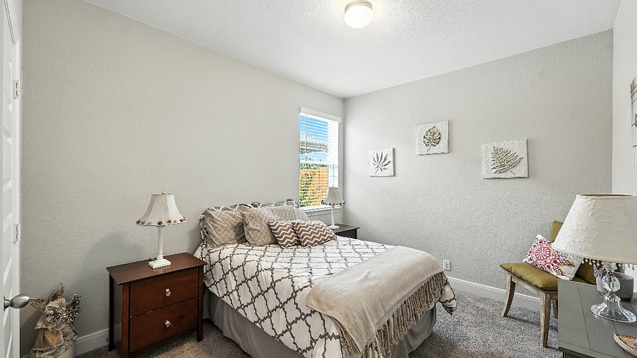 Another angle of the guest bedroom showing plenty of space, natural light, and cozy details that make it feel like home.