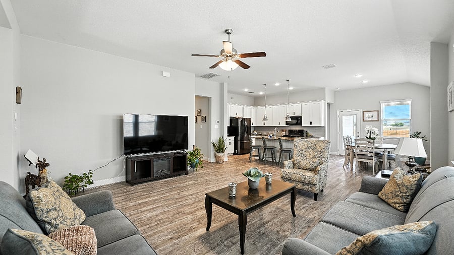 Wide-angle view of the open living, dining, and kitchen spaceeasy flow that works well for everyday living.