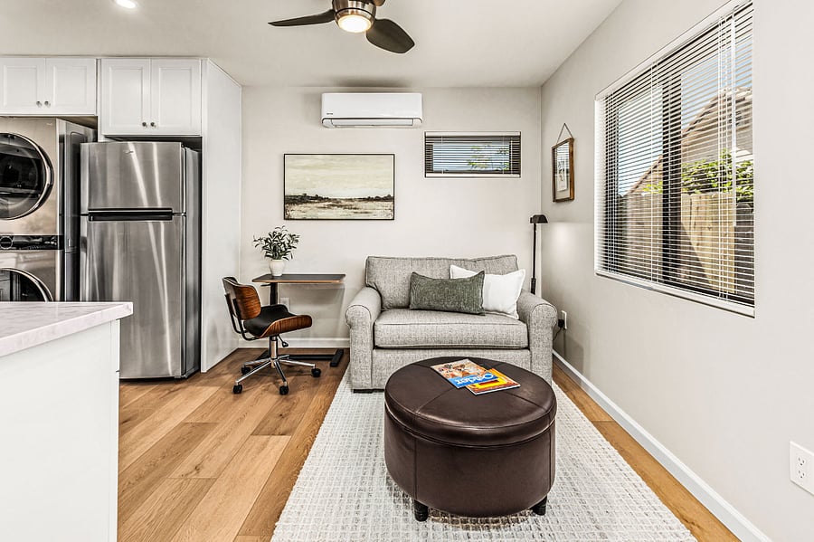 Living area with rolling, adjustable height task table/standing desk and extremely comfortable rolling task chair, plus a loveseat that opens to a single sleeper for the occasional overnight guest.