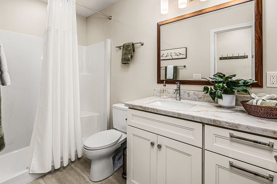 Spacious bathroom and shower with plenty of storage and electrical outlets.
