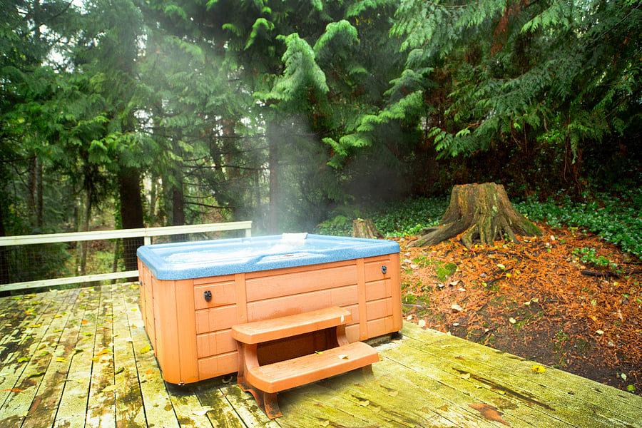 Private hot tub on back porch overlooking creek, trees, wildlife