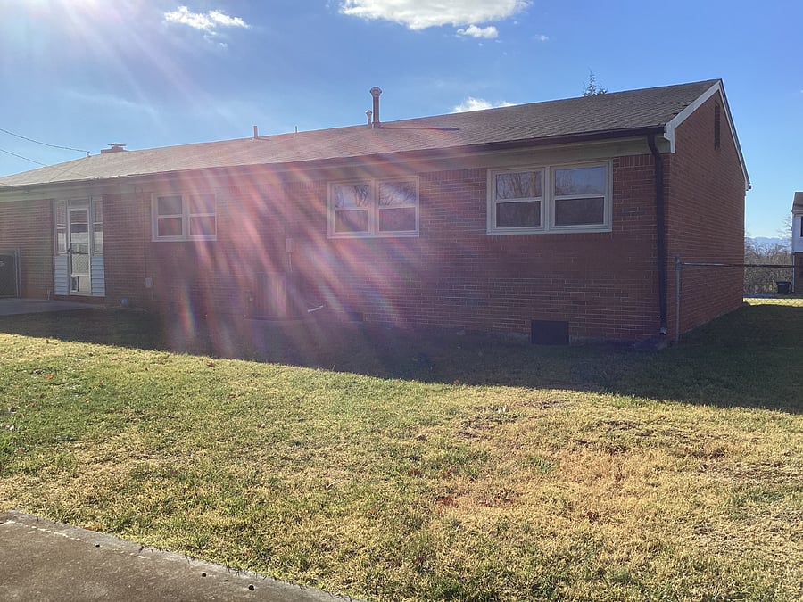 Back of the house with Fenced in Backyard and dog door.