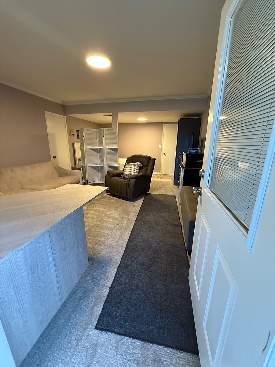 Living room to the unit. Fine with getting rid of the big chair if you'd prefer another chair or more space.