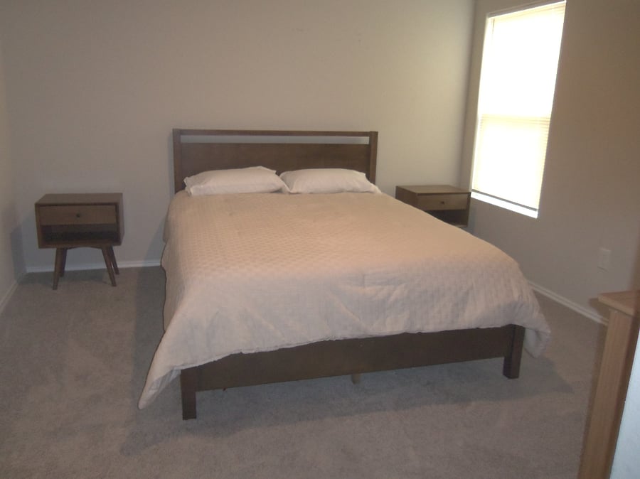 Primary bedroom, queen bed, nightstands, dresser, private bathroom and walk-in closet.