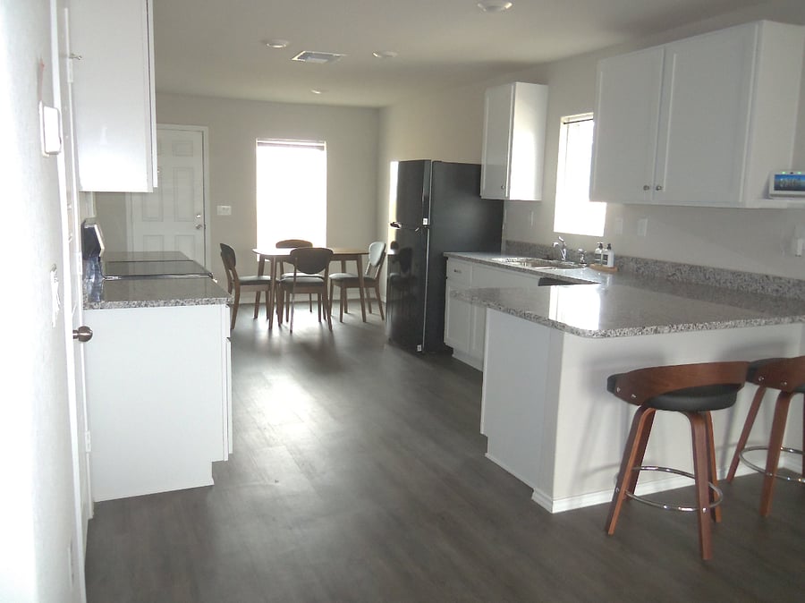 Kitchen, complete with dishwasher, utensils, cookware, dine-in countertops, full size refrigerator, stove and dining area.