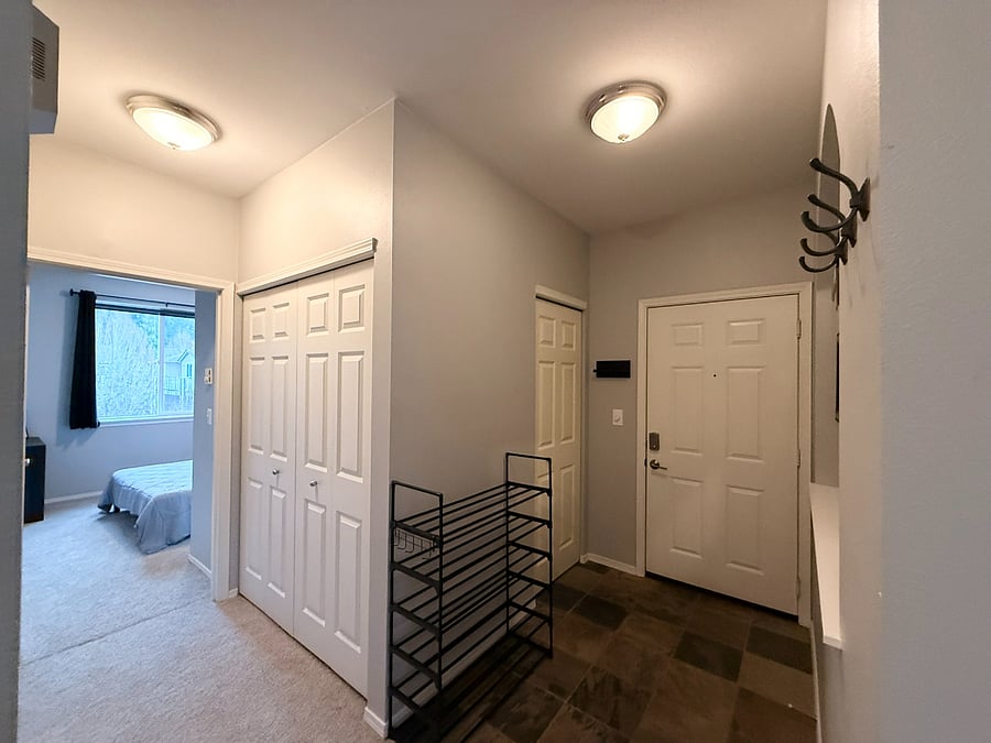Entry Way into the Condo Unit - Guest bedroom to the left & in-unit washer & dryer in the sliding closet doors
