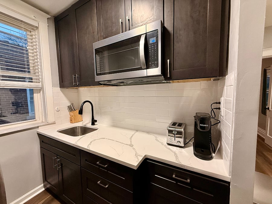 Quarts countertop, garbage disposal, and microwave.