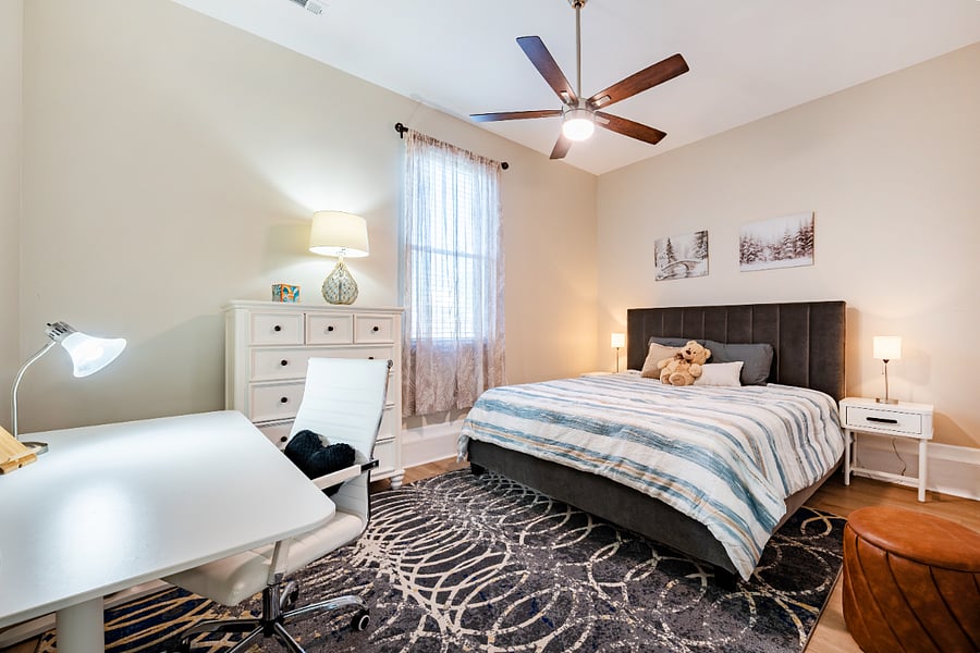 This room includes a large Ikea desk with a chair and dresser