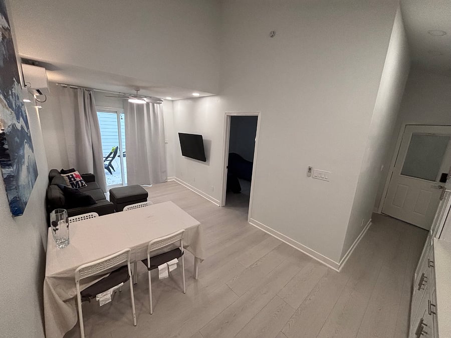 View of entry and living area with doorway to bedroom and patio.