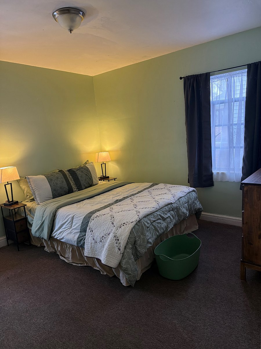 The Green Room is the Guest room. It contains a desk, chair, queen bed, dresser, nightstands and lamps.
