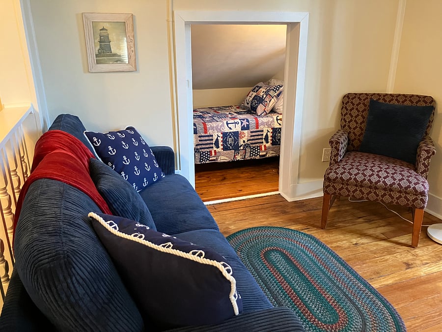 Living room with view of extra "alcove" bedroom with twin bed.