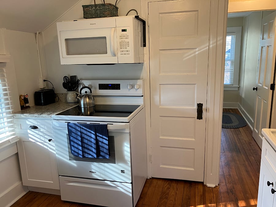 Fully equipped kitchen with dishwasher, fridge, stove/oven, microwave, & pantry space.