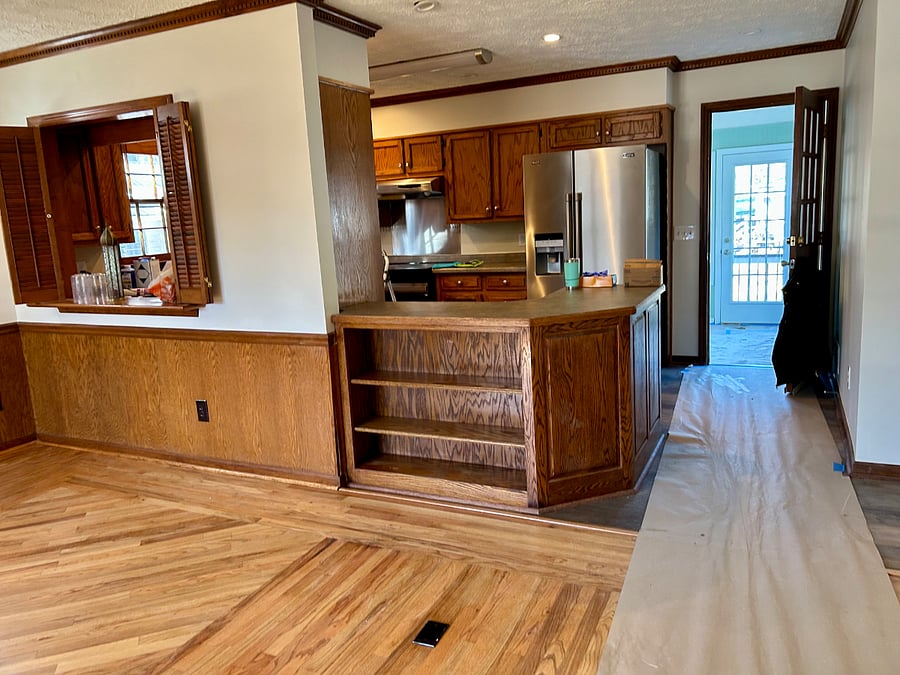 Shared space: The den is open to the kitchen, with a cool pass-through on the left and a kitchen peninsula with storage in the center.