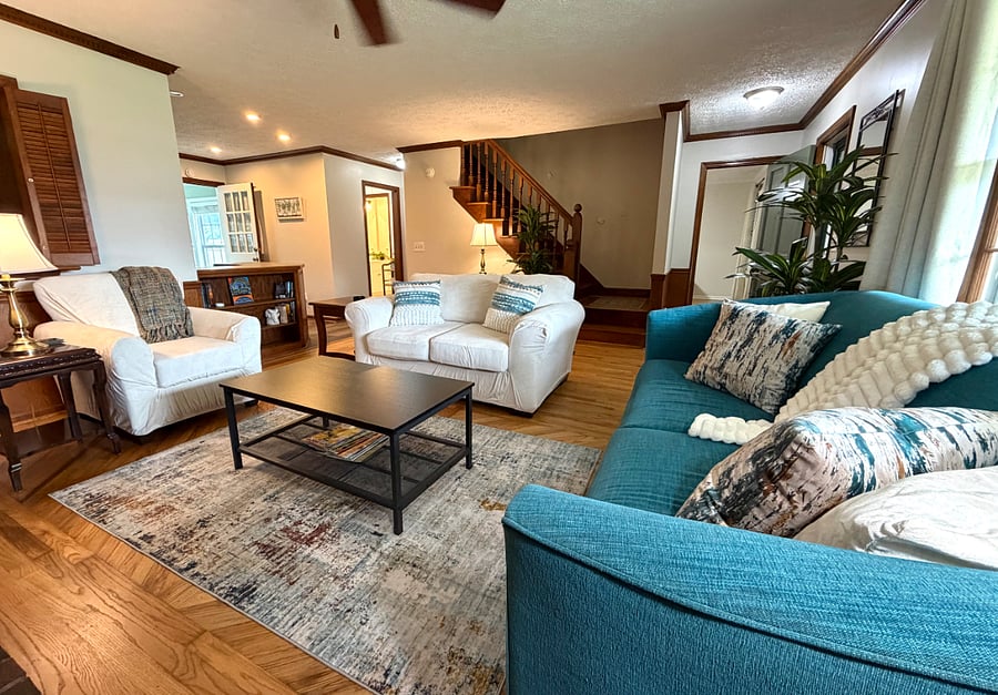 SHARED AREA: Warm and comfortable living room is open to the kitchen and coffee bar.
