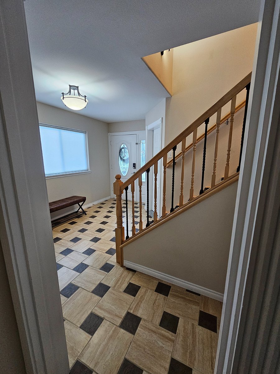 View of entryway and stairs from downstairs hallway