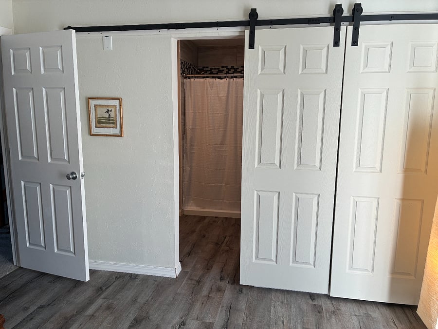 Barn door entrances to bathroom and closet.