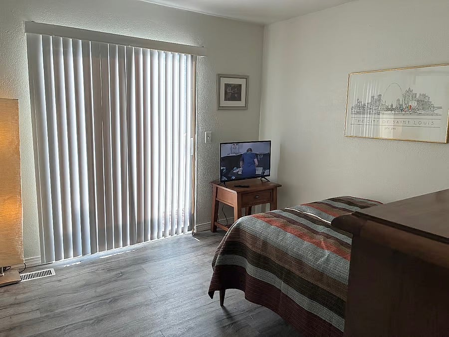 Bedroom has sliding glass door to balcony.