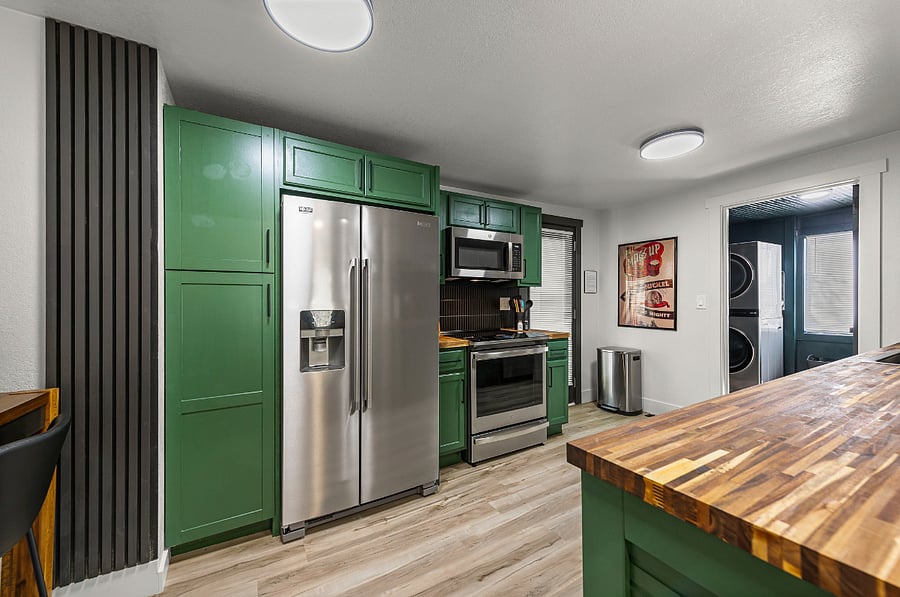 This modern kitchen flows seamlessly to the laundry area, fourth bedroom, and door to the private fenced backyard. With sleek appliances and thoughtful design, its the perfect hub for both convenience and connection during your stay in Independence.
