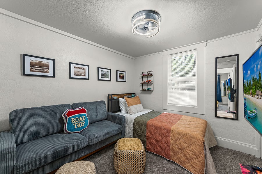 This twin bedroom is made for comfort and fun with a plush bed, vintage car art, and a cozy sofa to relax on. Stream your favorite shows or hook up your own game system for the ultimate chill space after exploring the city.