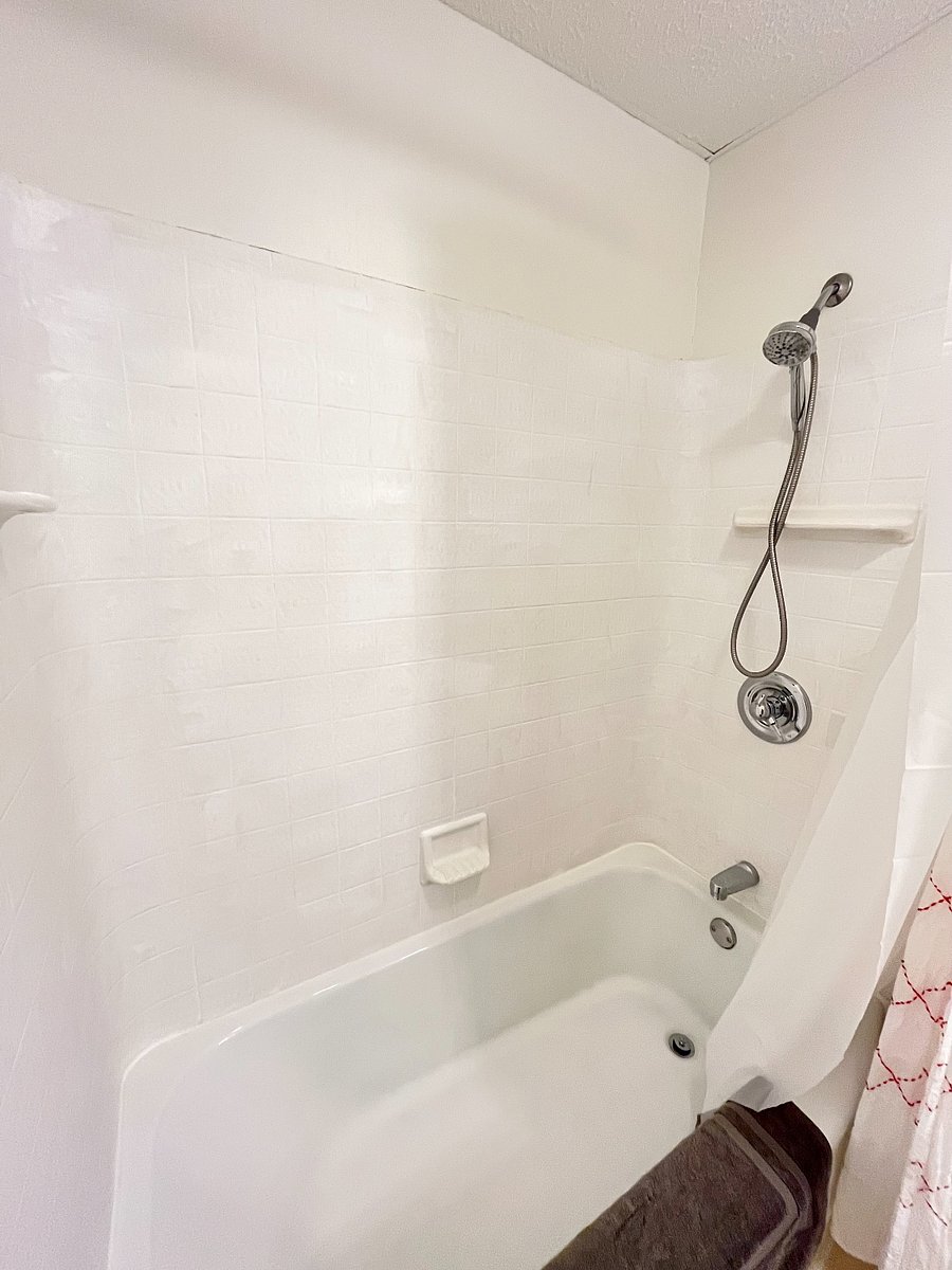 sparklingly clean tub/shower combo with handheld shower head for convenience