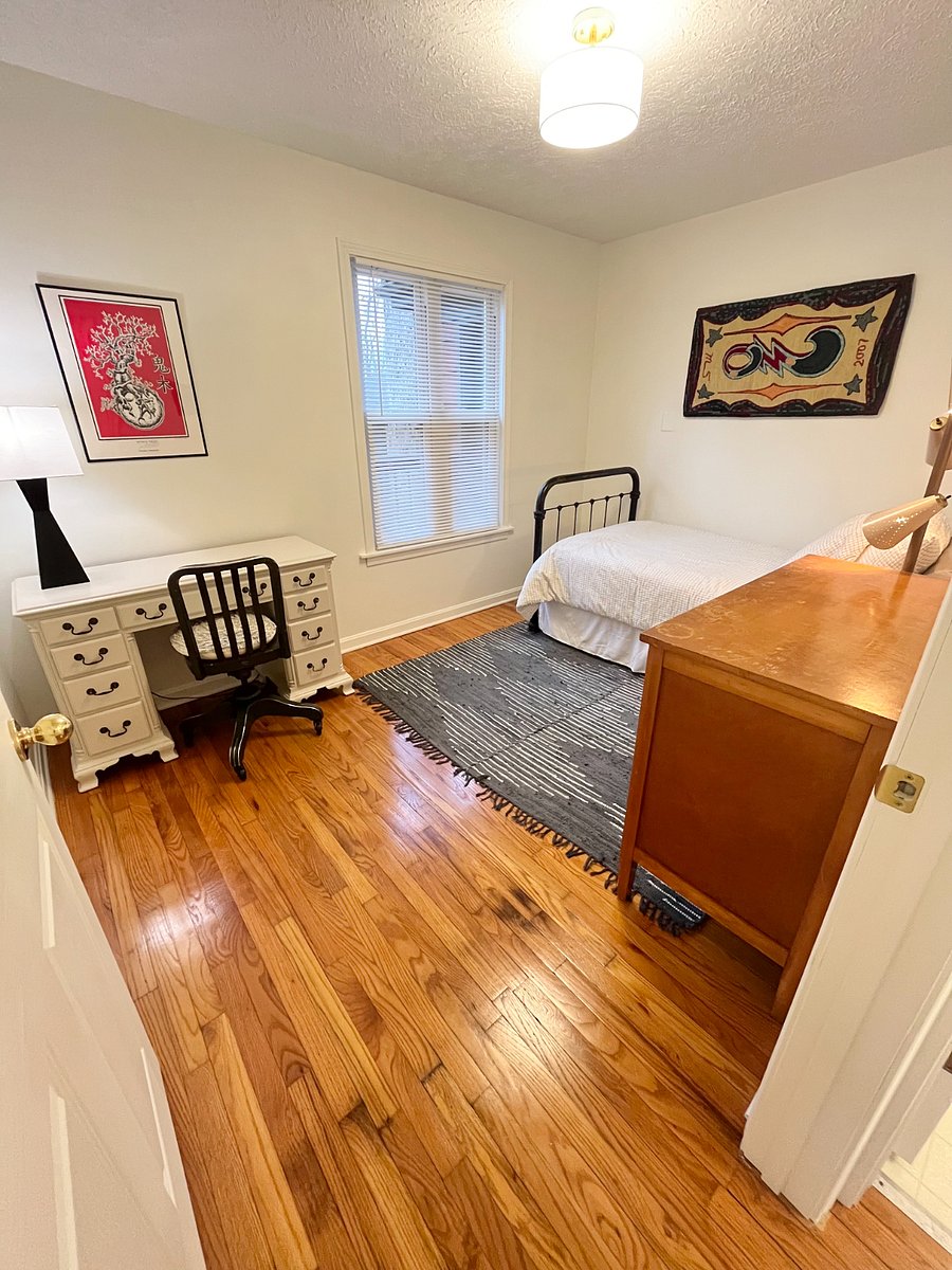 second bedroom with twin bed and dedicated workspace and privacy blinds