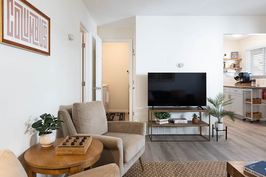 Comfortable living room with sofa, accent chairs, and smart TV