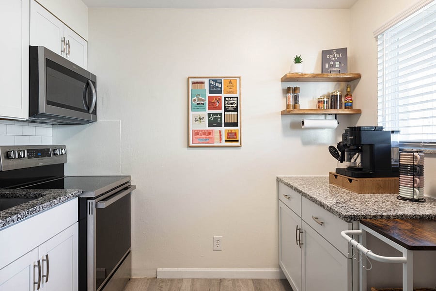 Kitchen featuring full-size refrigerator, stove, and microwave