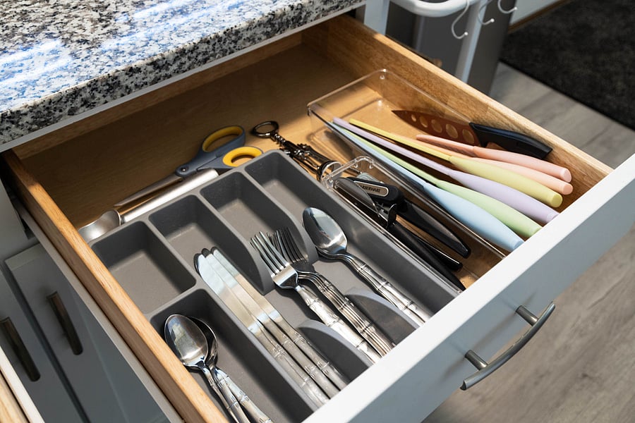 Kitchen drawers fully stocked with utensils, measuring tools, and storage supplies.
