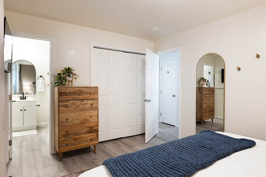 Bedroom includes a full-length mirror for easy outfit checks and getting ready.