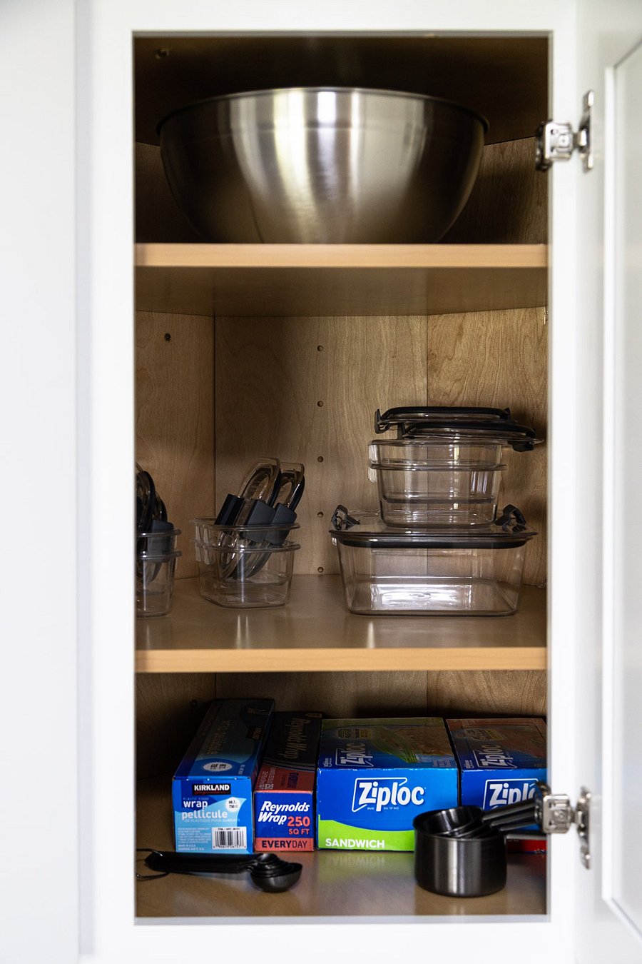 Additional kitchen storage with cookware and containers.