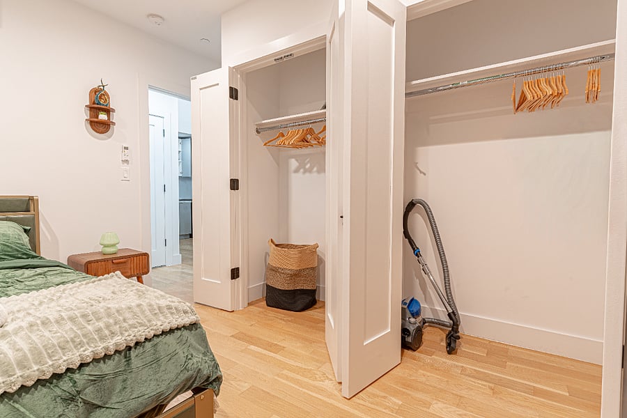 Primary bedroom setup with cozy bedding, AC, and a warm mid-century feel for restful nights.