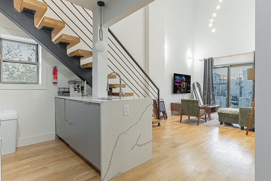 Open-concept living space connecting kitchen, dining, and stairs to the upper floor.