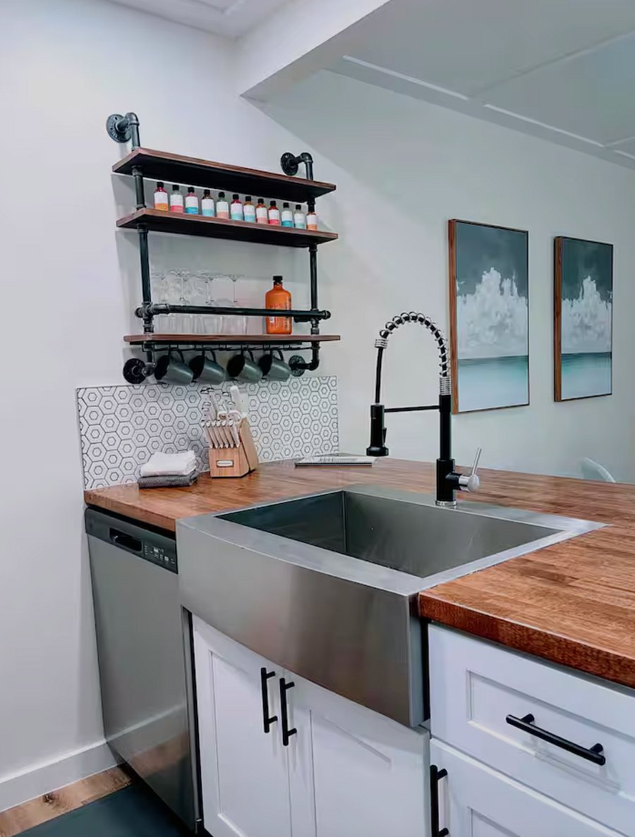 Well stocked kitchen with large deep sink, dishwasher, and breakfast bar