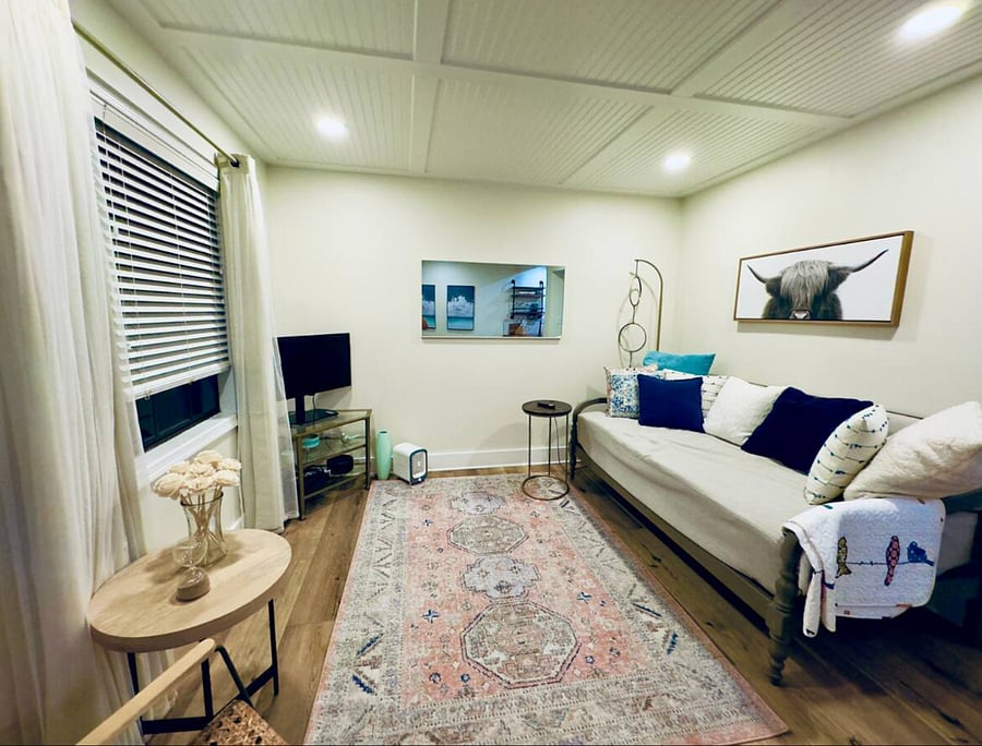 Large living space with smart TV and comfy day bed for guests